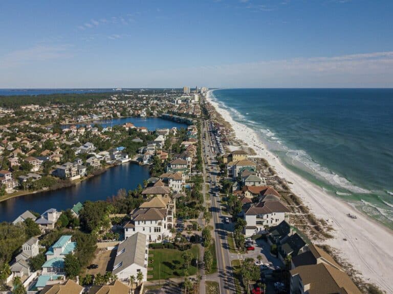 Aerial view of luxury coastal homes along a Florida beach, representing the lifestyle awaiting buyers relocating to Florida
